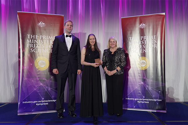 Photo of Associate Professor Elizabeth New on stage receiving her award.