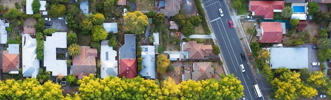 Aerial shot of houses and a road in a suburb.