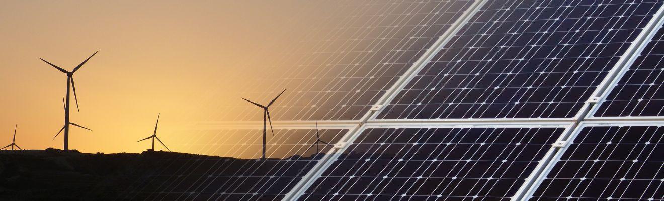 Solar panels in front of a wind farm.