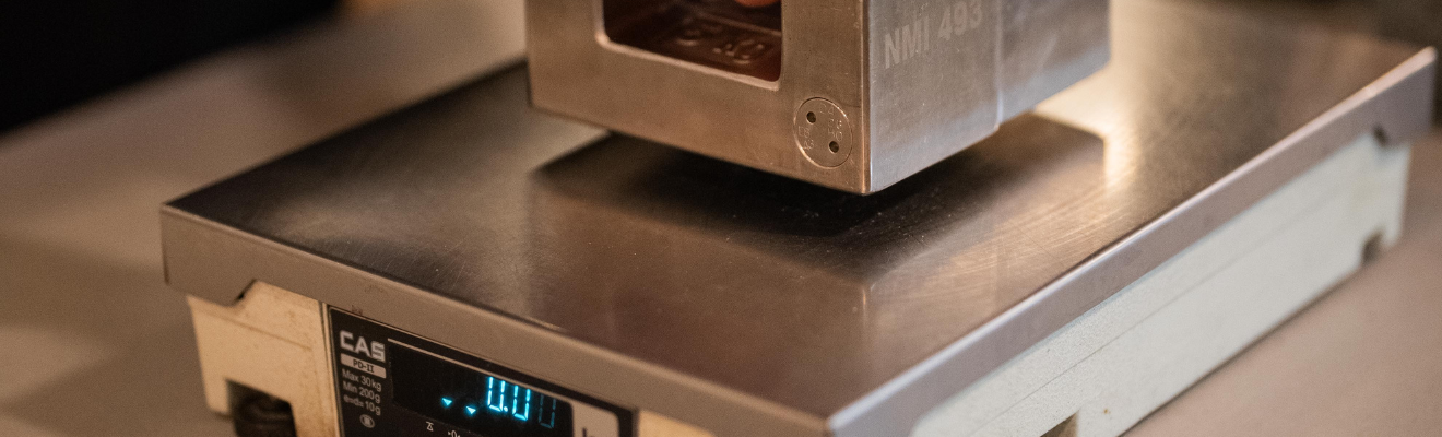 Trade Measurement Officer testing a NAWI (non-automatic weighing instrument) in use for trade. 