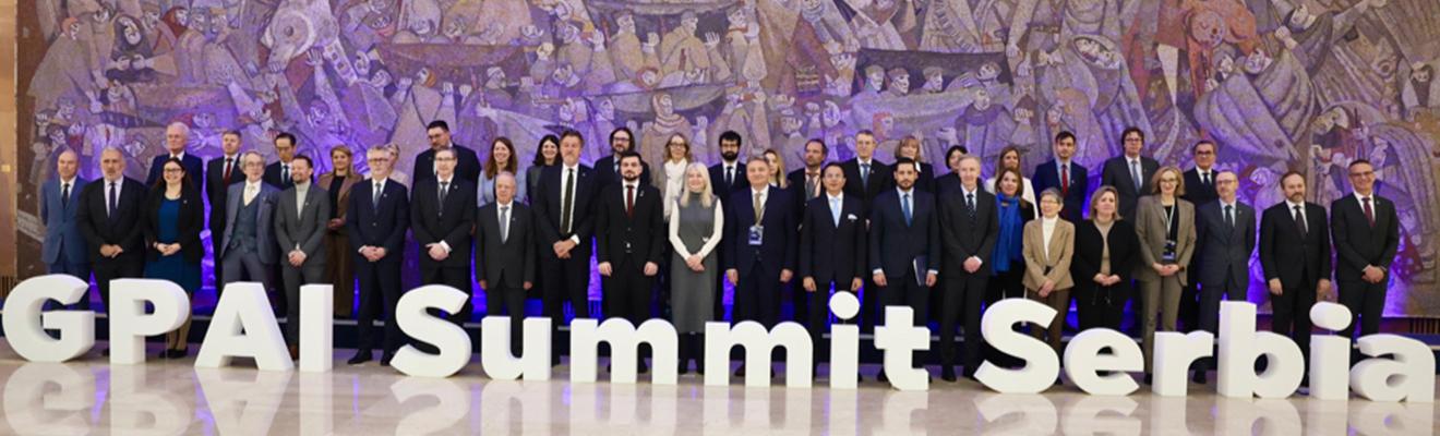 A group photo of representatives, standing behind large letters that spell out ‘GPAI Summit Serbia’.  