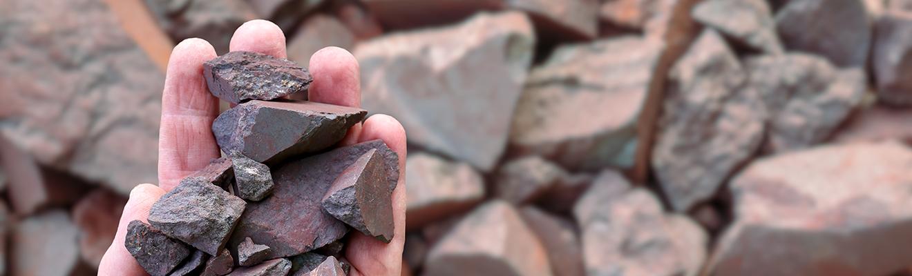 Image of a hand holding pieces of high-grade Australian iron ore.