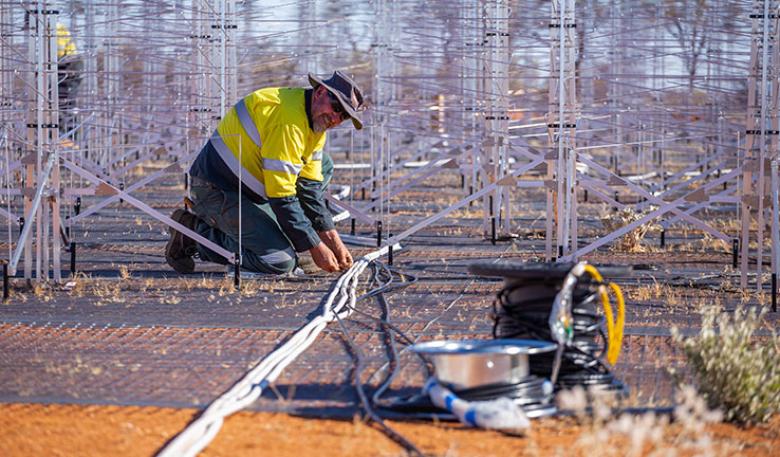 A man lays a cable for the prototype of the SKA-Low.