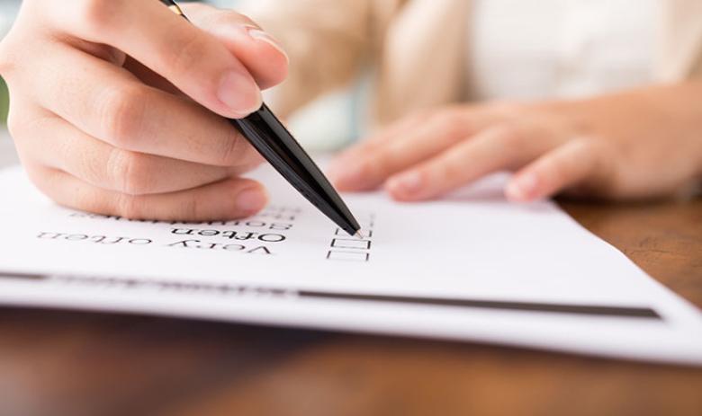 Photo of someone’s hand filling in a form