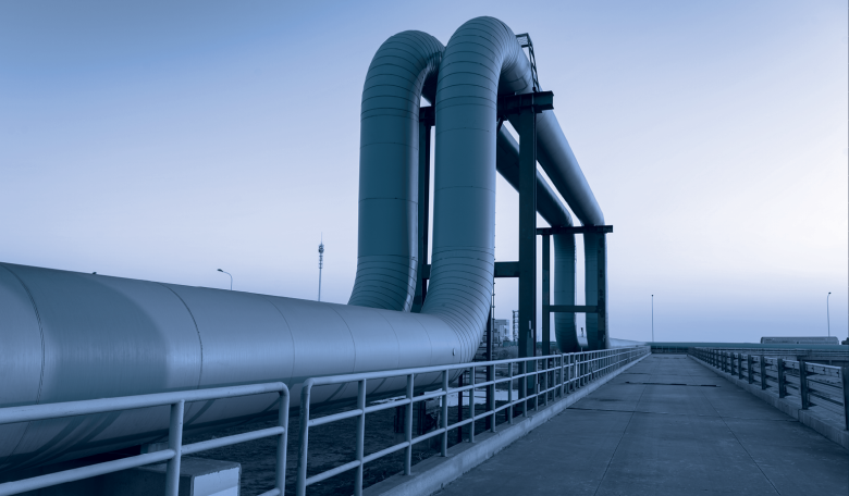 Image of blue pipes going to an oil refinery.