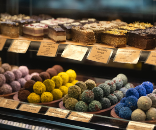 A selection of cakes and patisseries items for sale behind a glass counter