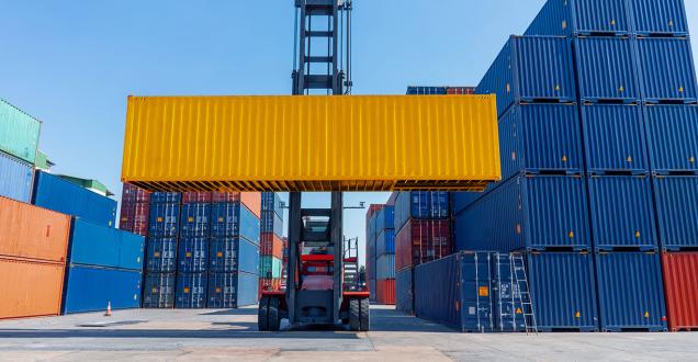 Forklift moving shipping containers at a port