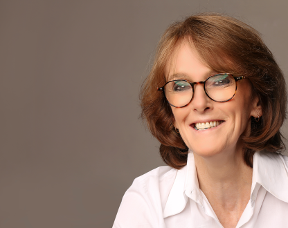 Woman wearing glasses smiling at camera