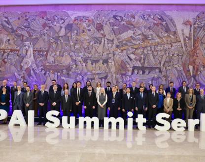 A group photo of representatives, standing behind large letters that spell out ‘GPAI Summit Serbia’.  