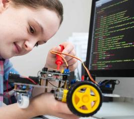 Photo of a girl building a car or robot